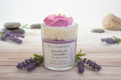 Scented candle labeled 'Serenity in Lavender' with lavender flowers and stones on a wooden surface.