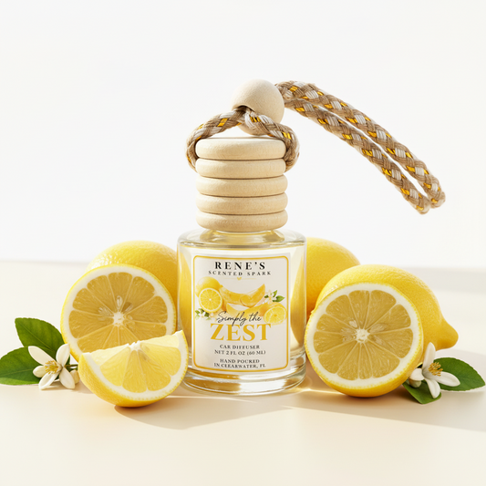 Simply the Zest lemon cake and vanilla hanging car freshener by Rene’s Scented Spark surrounded by fresh lemons and citrus blossoms. 🍋💛