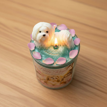 Candle with a dog figurine and pink petals on a wooden surface