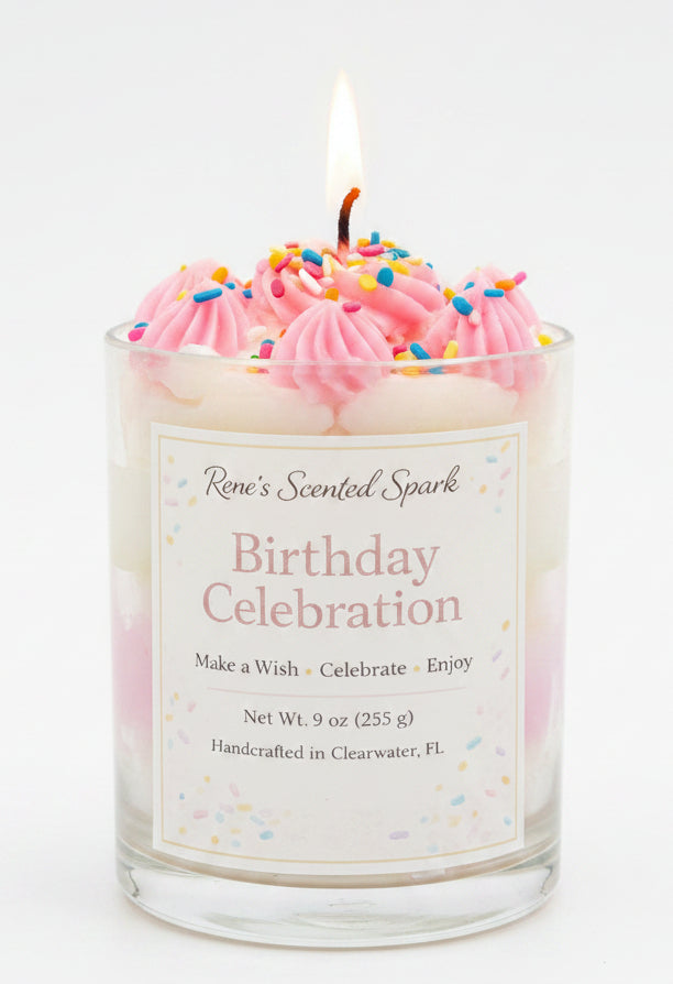 Birthday-themed candle with pink frosting and a 'Rene's Scented Spark' label, set against a festive background.
