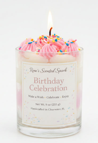 Birthday-themed candle with pink frosting and a 'Rene's Scented Spark' label, set against a festive background.