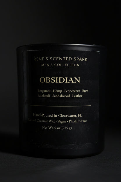 Black candle labeled 'Obsidian' from Rene's Scented Spark Men's Collection on a dark background