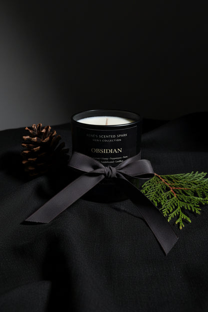 Black candle with a bow and decorative elements on a dark background
