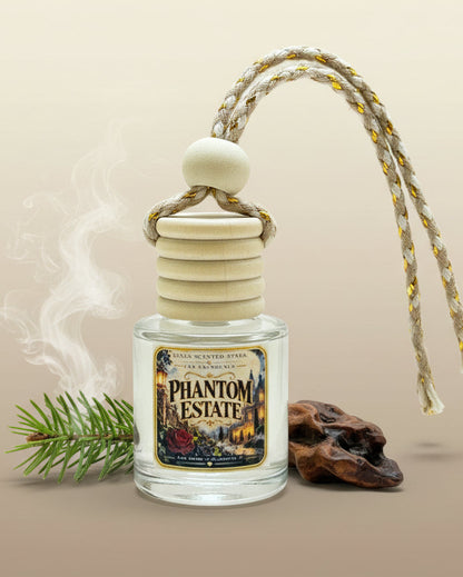Phantom Estate car freshener displayed with a fir sprig, dark wood and soft swirling mist against a warm neutral background.