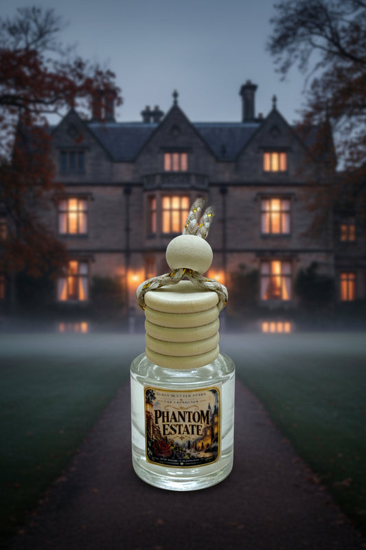 Phantom Estate hanging car freshener displayed in front of a misty old manor at dusk with glowing windows and dark autumn trees.