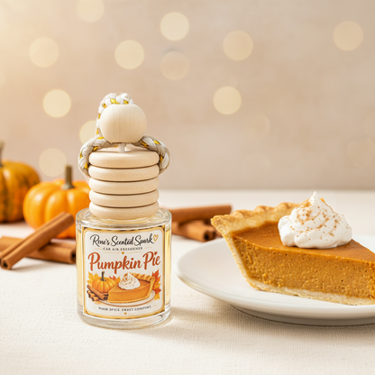 Pumpkin Pie car freshener by Rene’s Scented Spark displayed beside a slice of pumpkin pie, cinnamon sticks, and mini pumpkins in a warm fall setting.
