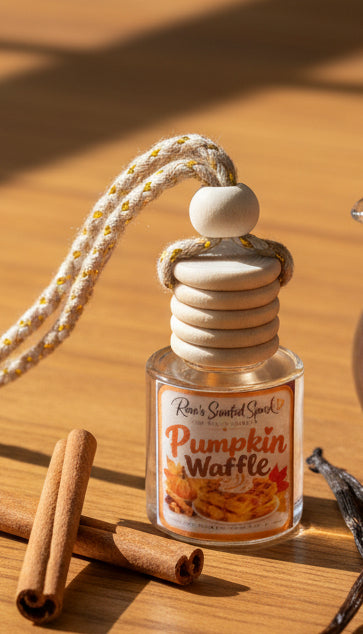 Pumpkin Waffle hanging car freshener by Rene’s Scented Spark styled on a warm wooden surface with cinnamon sticks and vanilla beans in golden autumn sunlight.