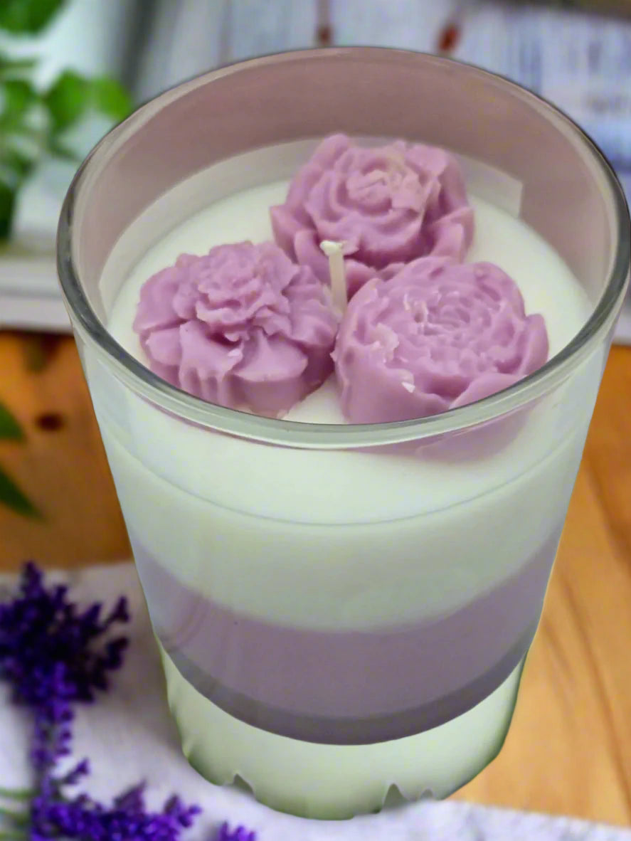 Lovely Lavender candle glowing on a table beside books and flowers, creating a spa-like, calming atmosphere — perfect for self-care or gifting