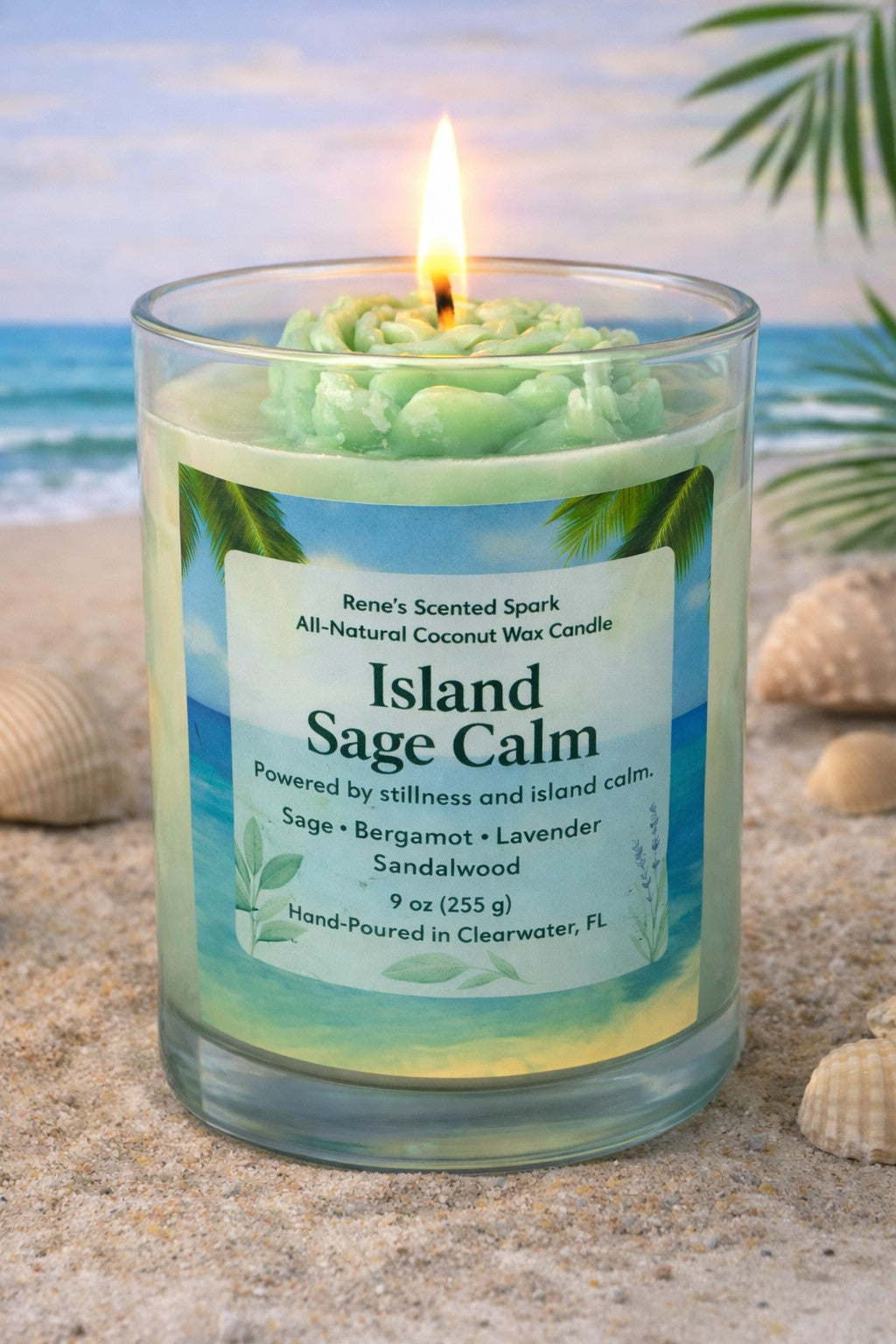Candle labeled 'Island Sage Calm' on a beach with ocean view