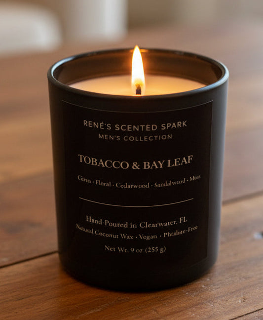 Candle with 'Tobacco & Bay Leaf' fragrance on a wooden surface