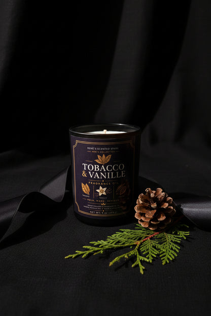 Candle in a can labeled 'Tobacco & Vanille' with decorative elements on a dark background