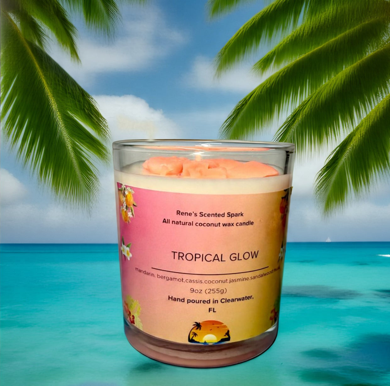 Tropical Glow coconut wax candle by Rene’s Scented Spark with a coral-colored wax top, in a glass jar with tropical floral label. Hand-poured in Clearwater, FL. Scented with mandarin, cassis, coconut, jasmine, sandalwood, and musk. Gift-ready tropical candle