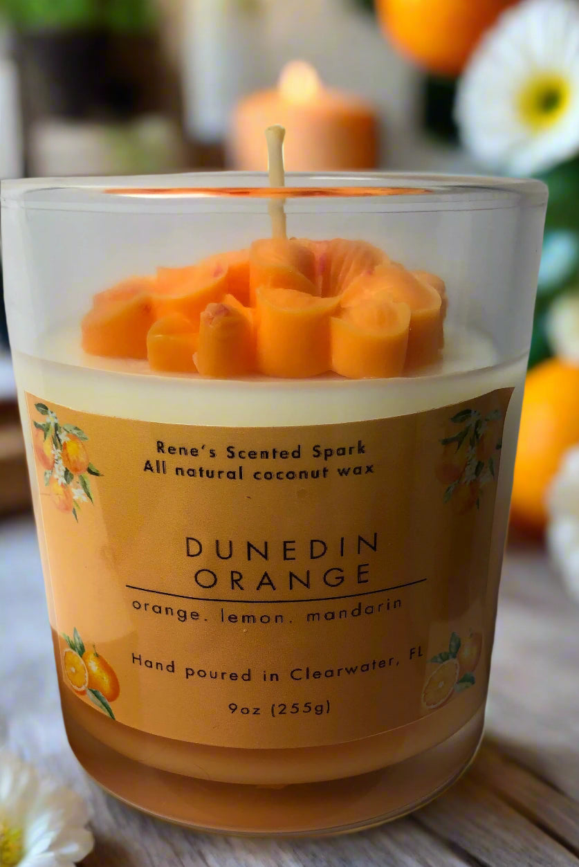 Handcrafted Dunedin Orange candle in gift-ready packaging, citrus blossom design with orange and white wax, inspired by Dunedin art