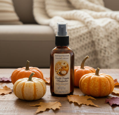 Vanilla Pumpkin Marshmallow room and linen spray by Rene’s Scented Spark in an amber spray bottle, surrounded by orange and white pumpkins, autumn leaves, and a cozy cream knit blanket.
