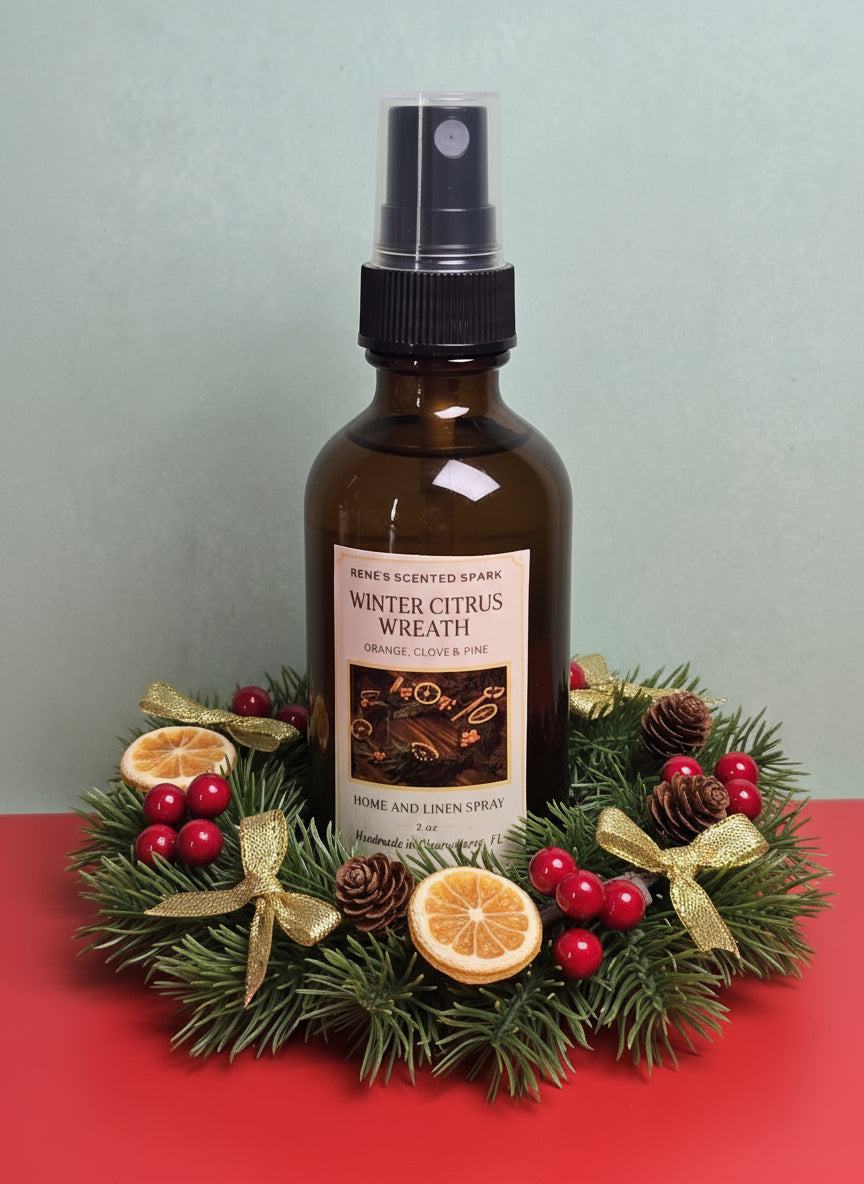 Bottle of 'Winter Citrus Wreath' home and linen spray surrounded by a decorative wreath on a red surface.