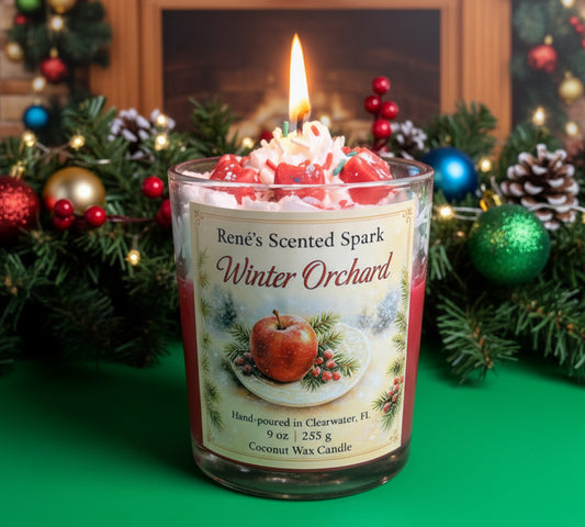 Candle labeled 'Rene's Scented Spark Winter Orchard' with Christmas decorations in the background
